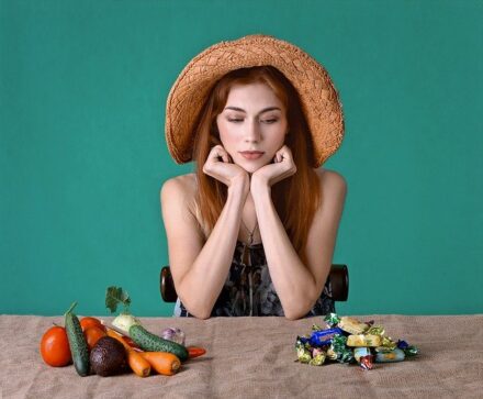 femme à chapeau devant table