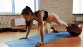 femme en train de réaliser une planche avec ballon fitness