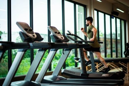 homme en train de courir sur un tapis de cours en club de sport