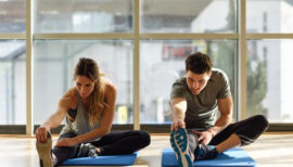 une femme et un homme sur tapis de gym en plein étirement