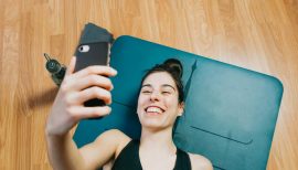 femme au sol sur tapis de gym en train de prendre un selfy