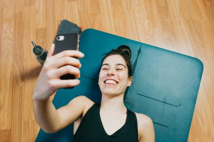 femme au sol sur tapis de gym en train de prendre un selfy