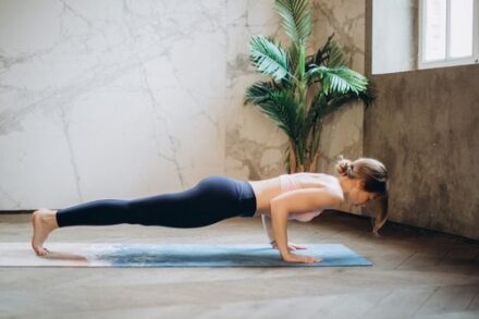 femme faisant la planche face au sol sur tapis de gym