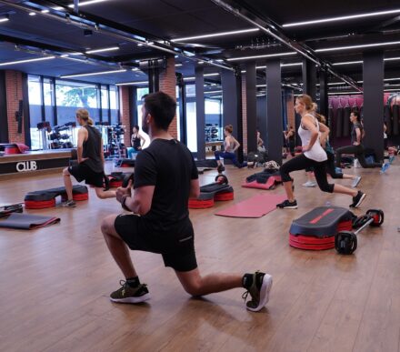 cours collectif fitness avec femmes en train de faire des fentes