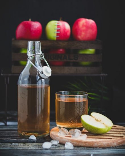 bouteille de vinaigre de cidre entouré de pommes