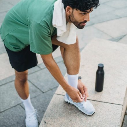homme faisant son lacet avant de courir