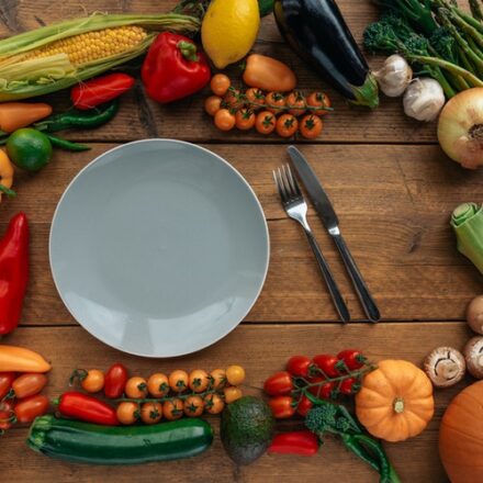 assortiment de légumes crus disposés autour d'une assiette