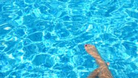 jambes immergées dans l'eau d'une piscine