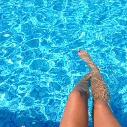 jambes immergées dans l'eau d'une piscine