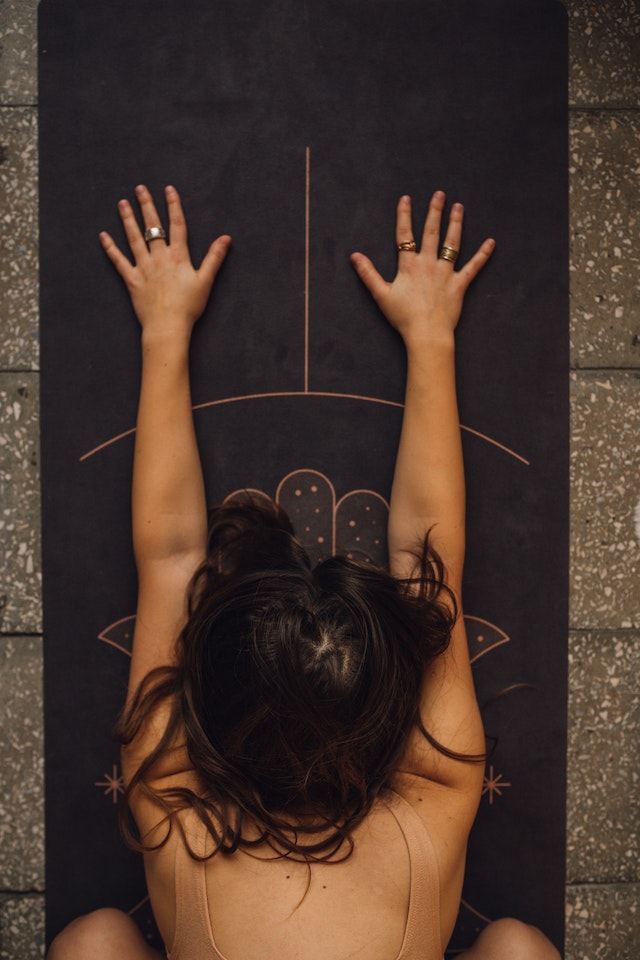 femme sur tapis de yoga marron