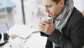 homme enrhumé qui boit une tisane