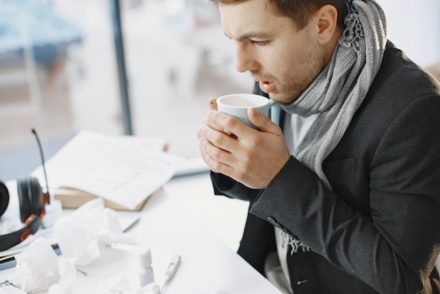 homme enrhumé qui boit une tisane