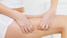 femme touchant la cellulite de sa cuisse