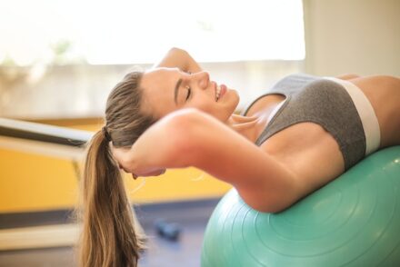 femme en brassière de sport sur un ballon fitness