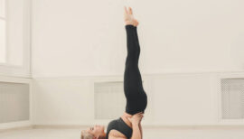 femme pratiquant la chandelle sur son tapis de yoga