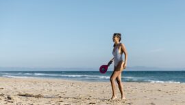 femme jouant aux raquettes sur le sable