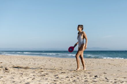 femme jouant aux raquettes sur le sable