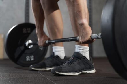 homme s'apprêtant à effectuer un romanian deadlift