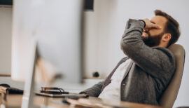 homme à son bureau présentant des signes de fatigue