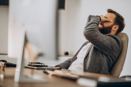 homme à son bureau présentant des signes de fatigue