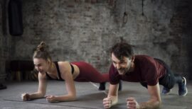 Couple de sportifs faisant la planche au gym