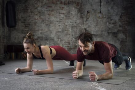 Couple de sportifs faisant la planche au gym