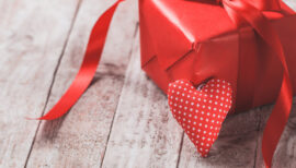 Paquet cadeau posé sur un parquet marron à l'occasion de la Saint Valentin