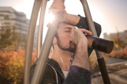 homme faisant du sport et entrain de boire sous le soleil