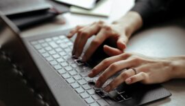 main de femme en train de taper sur un clavier d'ordinateur