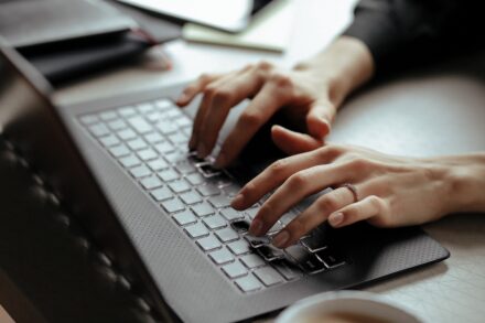 main de femme en train de taper sur un clavier d'ordinateur