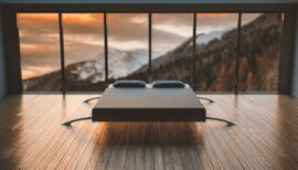 lit design au milieu d'une pièce épurée donnant sur la montagne