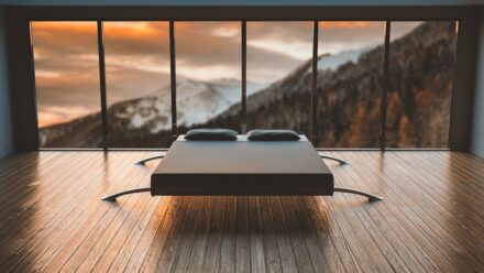 lit design au milieu d'une pièce épurée donnant sur la montagne
