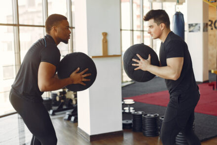 coach sportif et son élève tenant un ballon fitness