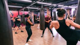 coach en train de rire avec un adhérent en cours de HIIT boxing