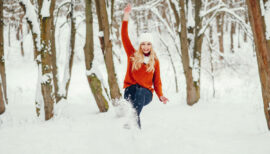 femme en forme sautant dans la neige, en pleine nature