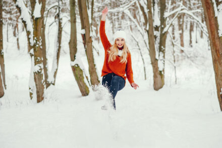 femme en forme sautant dans la neige, en pleine nature