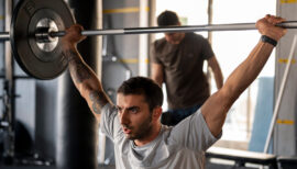 homme pratiquant le développé militaire au gym