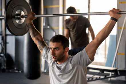 homme pratiquant le développé militaire au gym