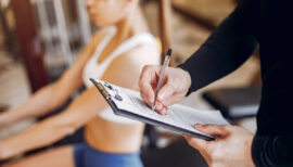femme faisant du sport avec un coach qui prend des notes