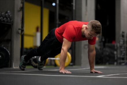 homme pratiquant l'HYROX et faisant l'exercice du Burpee Broad Jumps