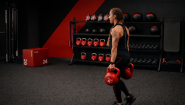 une femme s'entrainant en farmers carry hyrox