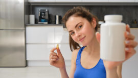 femme sportive tenant des probiotiques dans sa main