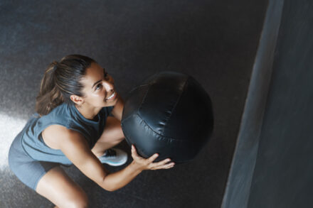 femme qui s'entraîne en wall ball pour une course HYROX