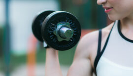 femme faisant preuve de force musculaire avec un haltère