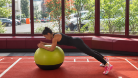 coach sportive faisant un exercice de gainage sur swissball