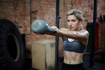 femme utilisant un kettlebell pour faire des exercices