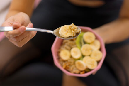 femme sportive prenant un repas de type collation avec banane